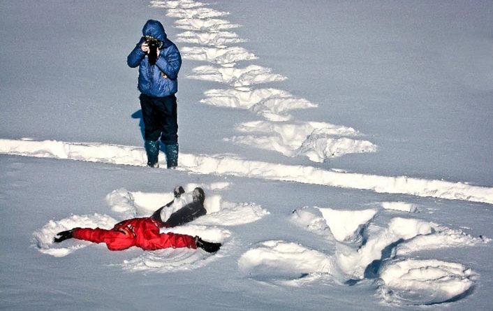 A person makes a snow angel.