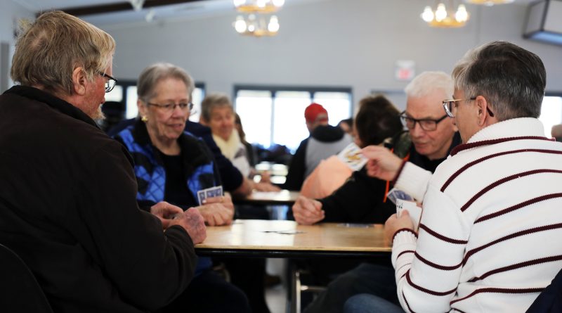 Four people play cards.