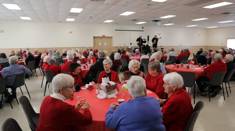 A room full of people enjoy a luncheon.