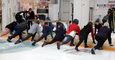 People stretch on a curling rink.