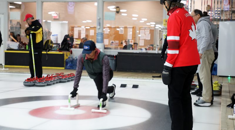 A person delivers a curling rock.