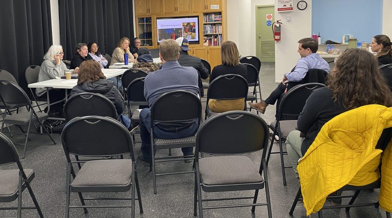 People sit at a meeting.