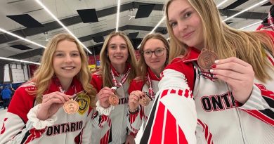 A photo of a team showing off their bronze medals.