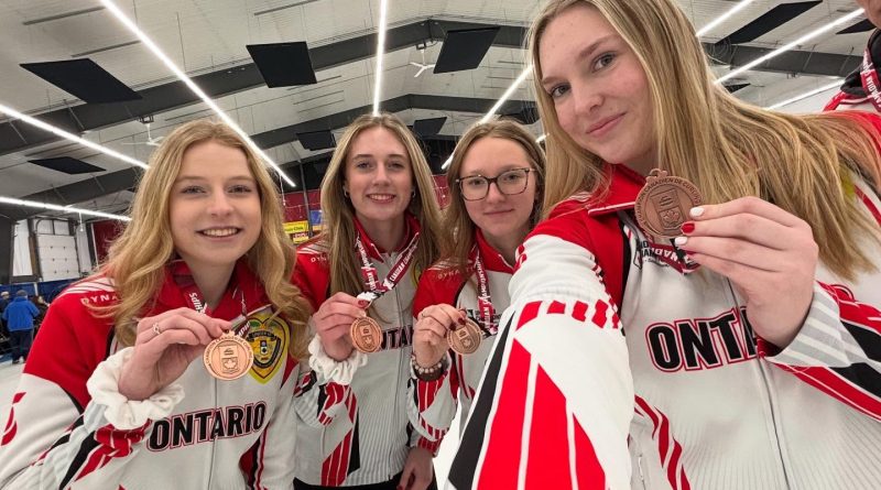 A photo of a team showing off their bronze medals.