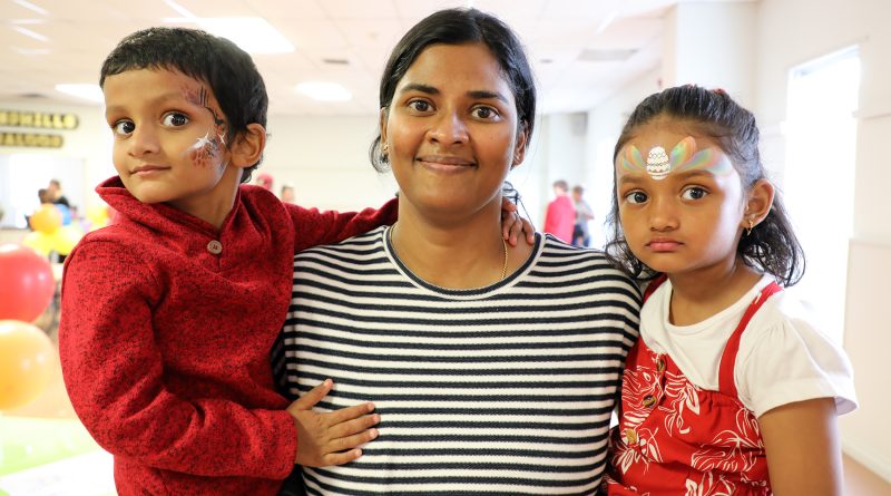 Three people, two with face paint, pose for a photo.