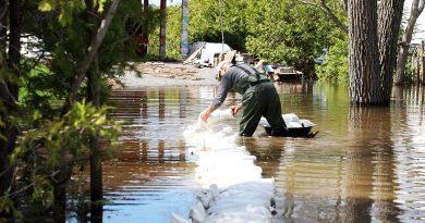 A man sets up sandbags in the water.