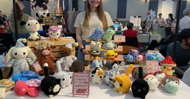 A women poses with crocheted items.