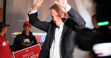 A man greets supporters in a room.