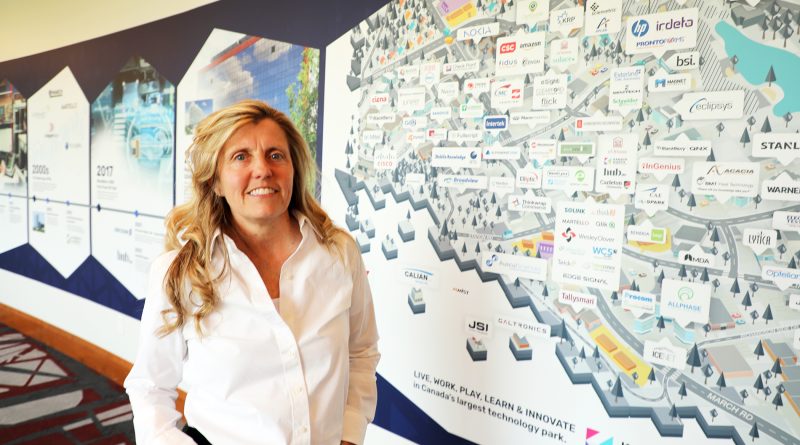 A politician poses beside a map of high tech companies.