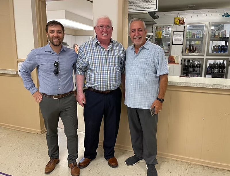 Three people pose for a photo.