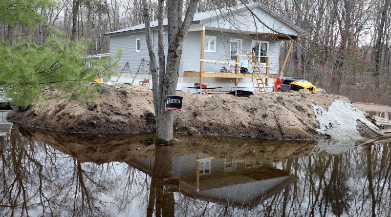 A house sits surrounded by water.