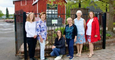 People pose in front of a sign.
