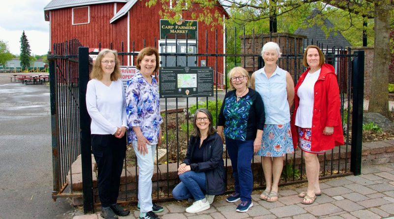People pose in front of a sign.