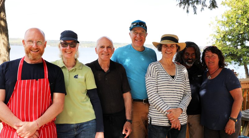 A group of people pose on a deck.