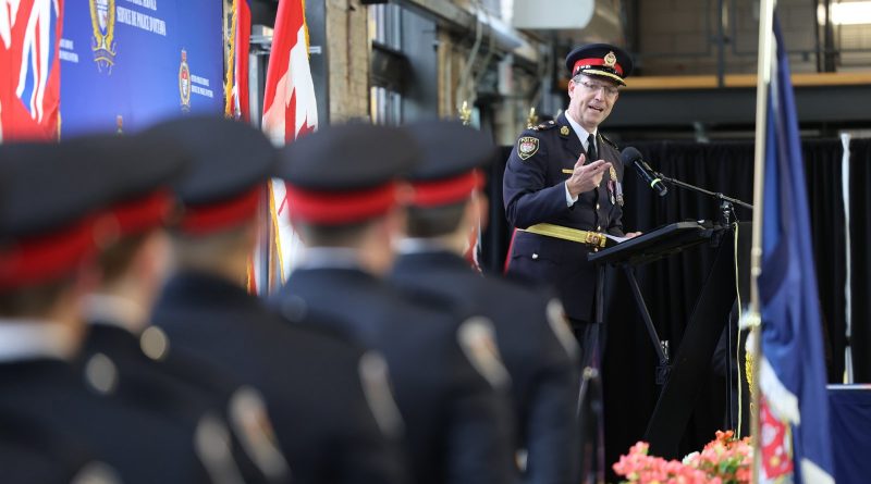 A photo of a police officer talking to new recruits.