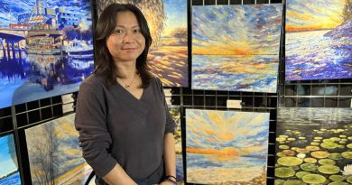 An artist poses with her work.