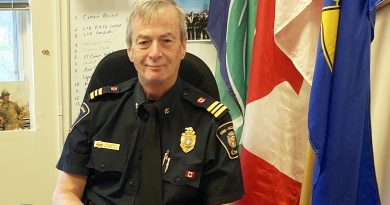 A fire chief sits in a chair.