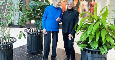 Two people pose in a mall.