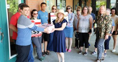 A group of people give a petition to a councillor.
