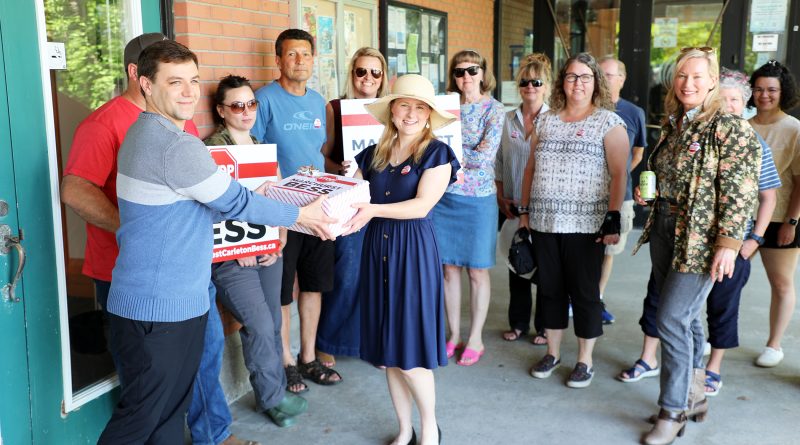 A group of people give a petition to a councillor.