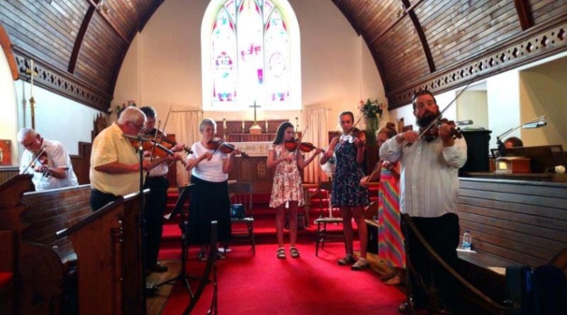 Fiddlers fiddle in a church.