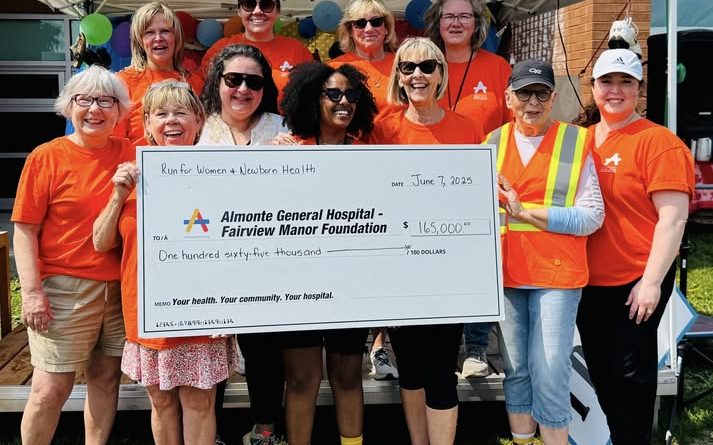 A group of people hold a cheque.