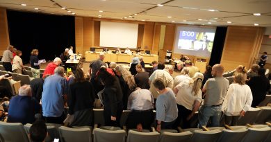 A group of people stand in an auditorium.