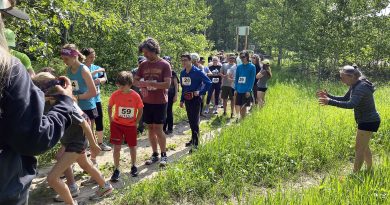A group of runners move through the forest.