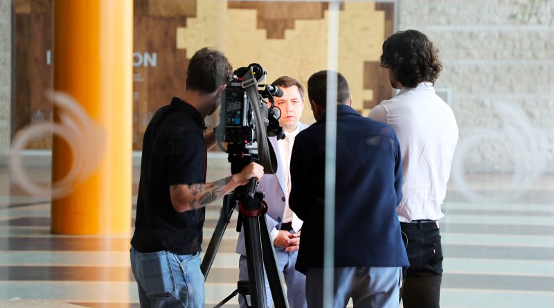 A person is interviewed by the press.