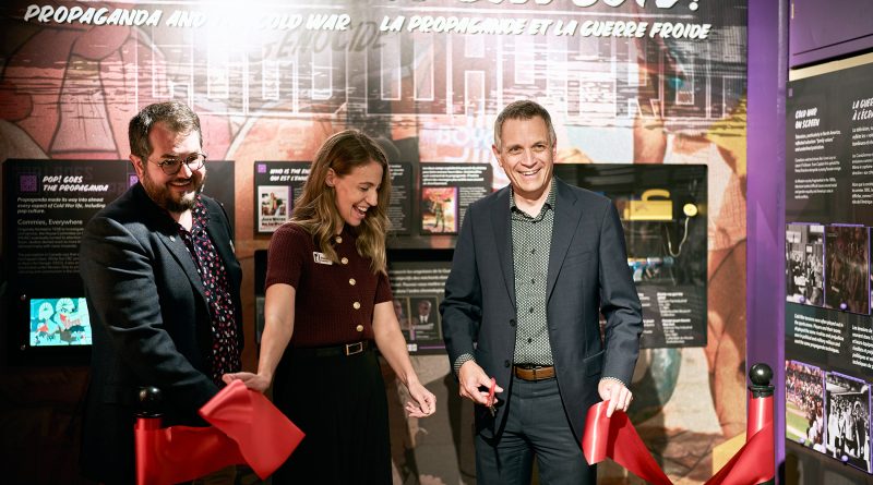 Three people cut a ribbon.