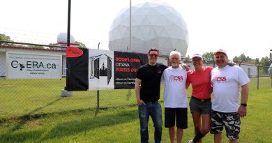 Four people pose outside the CSS Building.