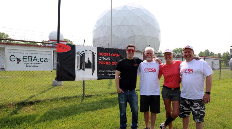 Four people pose outside the CSS Building.
