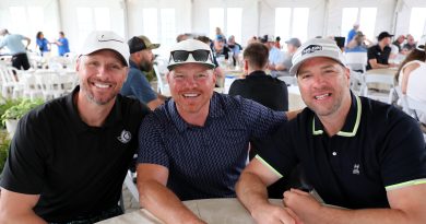 Three hockey players pose for a photo.