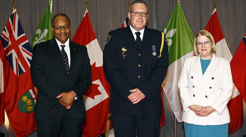 Three people pose for a photo.