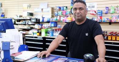 A man poses in his convenience store.