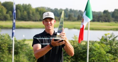 A golfer holds a trophy.