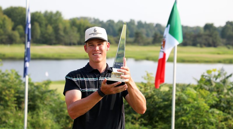 A golfer holds a trophy.