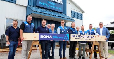 A group of people pose in front of a RONA store.
