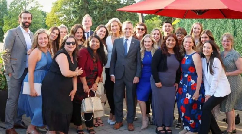 A group of people pose with the mayor for a photo.