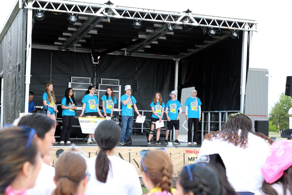 A group of people pose on a stage.