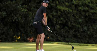 A man tees up on a golf course.