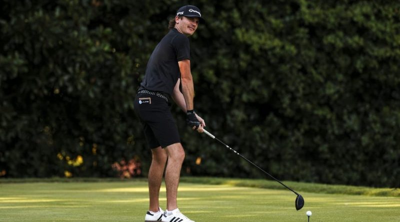 A man tees up on a golf course.