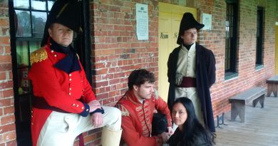 A photo of three people in historical costumes.
