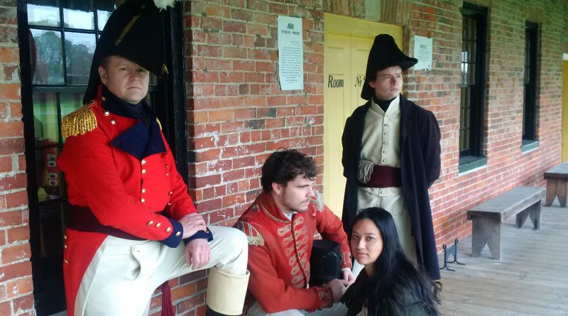 A photo of three people in historical costumes.