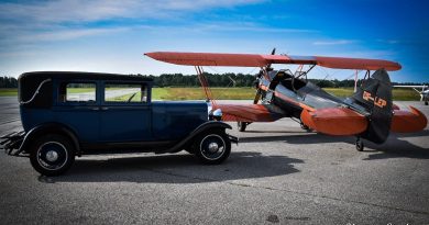 A photo of an old car and plane.