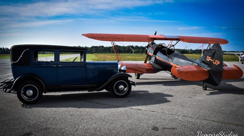 A photo of an old car and plane.