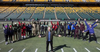 A photo of a group of people at a football field.