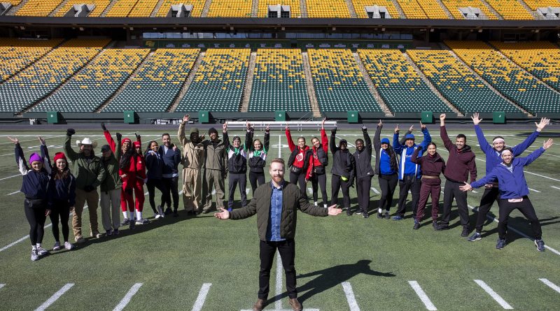 A photo of a group of people at a football field.