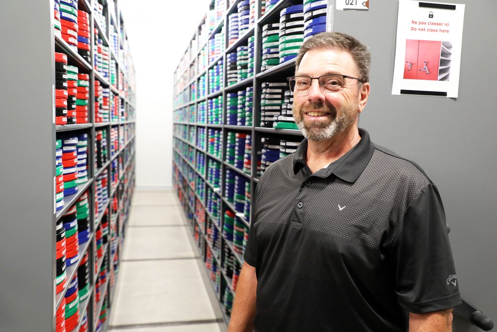 A man poses in an archives room.