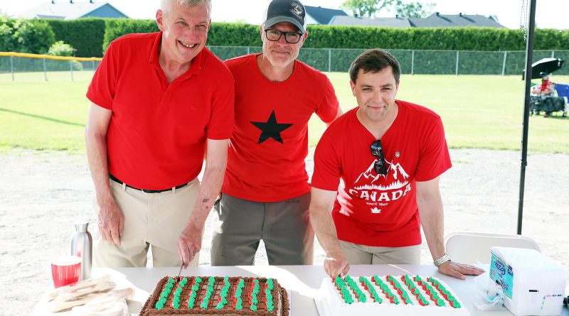 Three people cut a cake.
